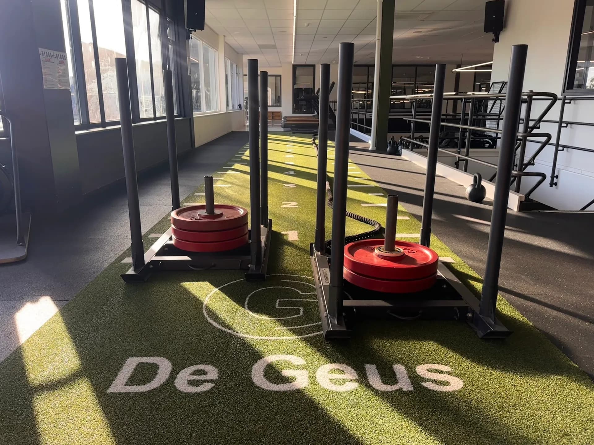 Twee sleds met gewichten op de kunstgrasbaan van De Geus Sport